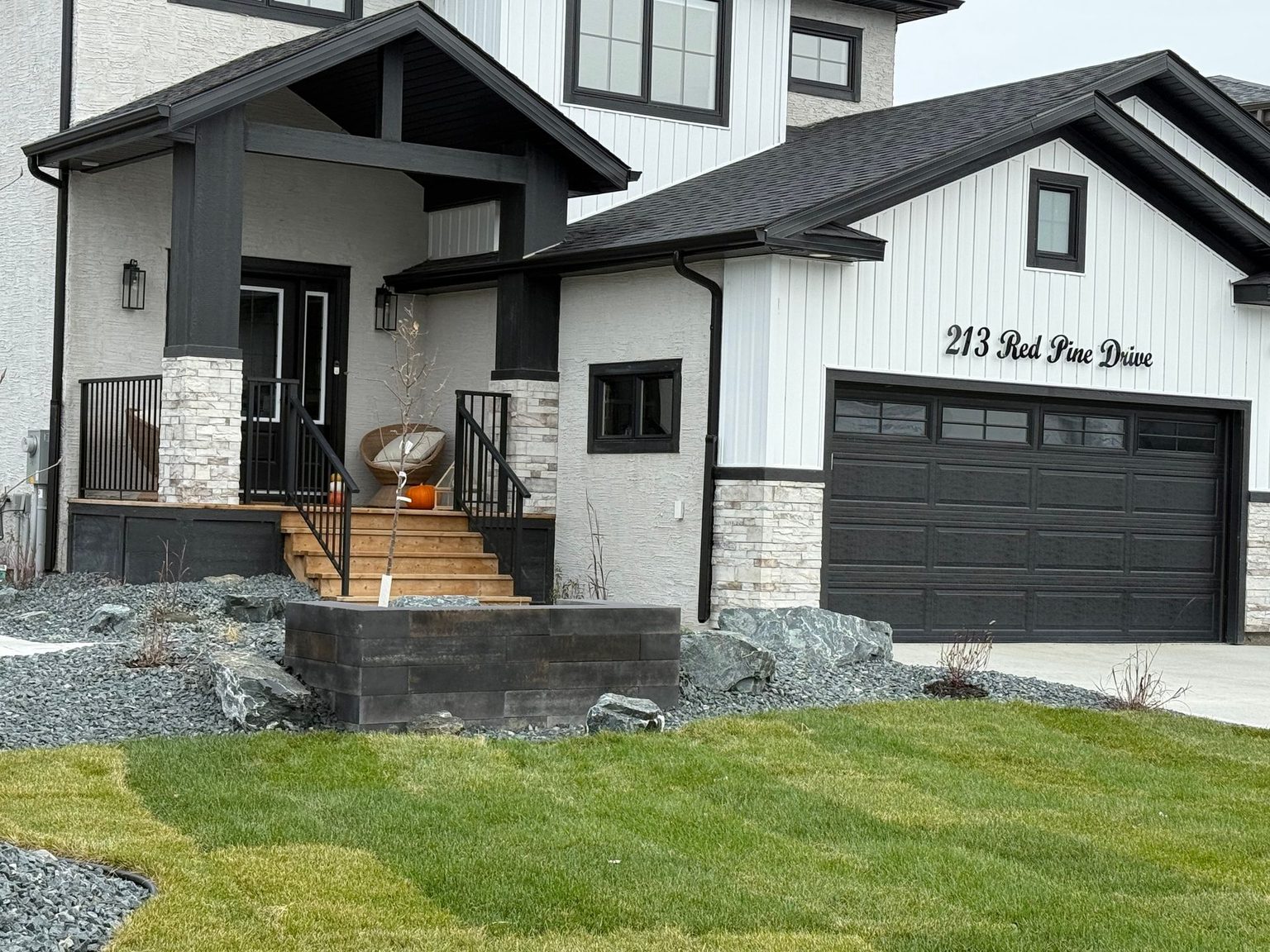 Finished front yard with new sod, a paver walkway and stone steps on a Winnipeg home